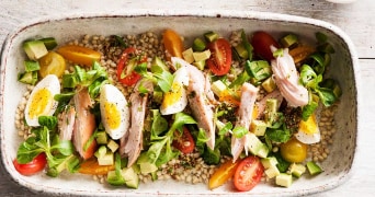 Salade met gerookte makreel, avocado, cherrytomaatjes en ei op een bedje van granen.