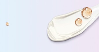 Roomwitte crème met transparante druppels op een lichtblauwe en roze achtergrond