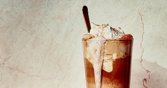 Glas ijskoffie met slagroom en cacao poeder