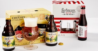La Chouffe en Liefmans Fruitesse bieren met verpakking op een tafel.