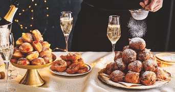 Schalen met oliebollen en champagne