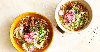 Ramen soep in kommen op een oranje achtergrond