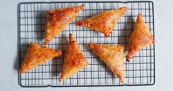 Verse bladerdeeg appelflappen op een zwarte rooster