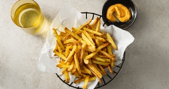 Friet met mayo en een glas water op een grijsbruine achtergrond