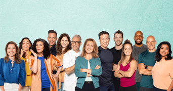 Groep mensen staand voor een lichtblauwe achtergrond