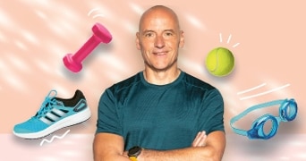 Man in sportkleding omringd door een blauwe Adidas tennisschoen, roze halter, tennisbal en zwembril tegen een roze achtergrond.