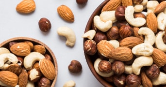 Een schaal met gemengde noten, waaronder amandelen, cashewnoten en hazelnoten.