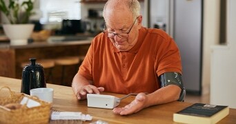 Man met een machine om zijn cholesterol waardes te meten.