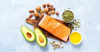 Producten die veel omega 3 bevatten zoals zalm, avocado, noten en pompoenpitten.
