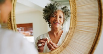 Persoon brengt lippenstift aan voor een ronde spiegel