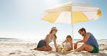 Gezin onder een strandparasol op het strand