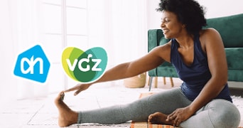 Vrouw die aan yoga doet met logo's van Albert Heijn en VGZ op de achtergrond