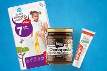 Producten van Albert Heijn, waaronder AH luiers maat 7, Elmex kindertandpasta, Kleine Keuken biologische chocopasta met hazelnoot, en Olvarit Groente knabbels.