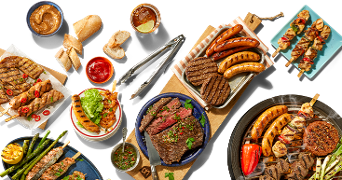 Diverse selectie van gegrild vlees, worstjes, spiesjes, groenten en brood, geschikt voor een barbecue, met verschillende sauzen en bijgerechten.