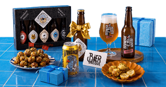 Assortiment met speciaalbieren van Brouwerij ’t IJ en Bird Brewery (Wingman IPA), glas bier, biercadeaupakket, biercheque, borrelhapjes en blauwe cadeauverpakkingen op een blauwe tegeltafel.