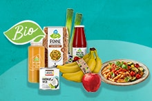 Biologische producten van Albert Heijn, waaronder penne pasta, tomatenpassata, kokosmelk, verse groenten, bananen, een rode appel, prei en een bereid pastagerecht, gepresenteerd met een bio-logo.