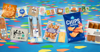 Assortiment van Albert Heijn producten met AH pizza, chips paprika, haring, verse jus d'orange, en worstenbroodjes.