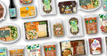 Verschillende Albert Heijn huismerk maaltijden, sauzen en verse ingrediënten tegen een zwarte achtergrond