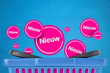 Roze cirkels met het woord "Nieuw" vliegen uit een blauwe boodschappenmand, ter aanduiding van nieuwe producten bij Albert Heijn.