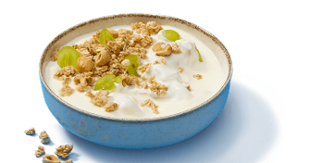 Kom met yoghurt, granola, groene druiven en hazelnoten
