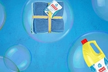 Schoonmaakproducten van Albert Heijn, inclusief vochtige doekjes, microvezeldoeken, en dikke bleek, gekozen tegen een achtergrond met zeepbellen.