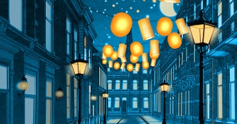 Straat met hangende oranje lampionnen en sfeervolle lantaarns lichtend in de nacht.
