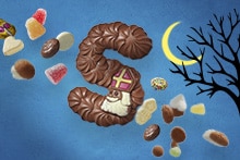Chocoladeletter S met Sinterklaasdecoratie, omringd door strooigoed, snoep en kruidnoten