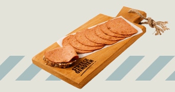 Gesneden plakken worst op een houten serveerplank met inscriptie "STREEKGENOTEN" en een stuk brood.