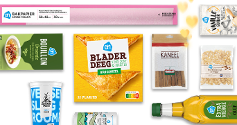 Verschillende Albert Heijn producten, waaronder bladerdeeg, bouillon, kaneelstokjes, extra vierge olijfolie, vanillecake, bakpapier en pompoenpitten.
