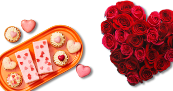 Bordje met Valentijn producten, macarons, tompouce en kleine gebakjes met hartjes. En een grote bos rozen in hartjesvorm