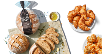 Heelbrood Liefde & Passie oerdesem, gesneden oerdesembrood, kleine bol oerdesembrood en een wit bord met croissants.