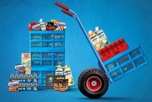 Blauwe Albert Heijn kratten en een steekkar met bulkboodschappen voor zakelijke bestellingen met cola, bier en tussendoortjes