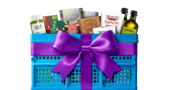 Blauwe geschenkkrat gevuld met luxe producten zoals Lindt chocolade, Raffaello, Carapelli olijfolie en Therme verzorging, versierd met een paarse strik