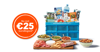 Blauwe Albert Heijn krat gevuld met diverse borrelproducten, zoals chips van Tyrrells, noten van John & Cashew, een fles water, en dips, met een houten plank met vleeswaren, kaas, crackers, olijven en een oranje label waarop staat “Nu met €25 borreltegoed”.
