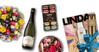Boeket bloemen, fles prosecco, macarons, tijdschrift LINDA met cadeauverpakking en verzorgingsproducten.