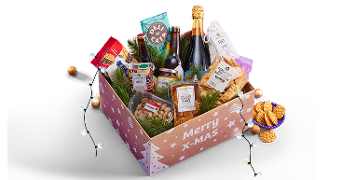 Feestelijke kerstcadeaudoos gevuld met verschillende luxe producten zoals kaas, noten, chips, wijn, champagne, koekjes en chocoladetruffels, versierd met dennentakken en kerstballen