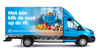 Albert Heijn bezorgwagen met promotietekst "Met één klik de zaak op de rit" en afbeeldingen van vers fruit, brood en boodschappenkratten.