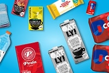 Blauwe Albert Heijn boodschappenkist gevuld met diverse producten, waaronder AH cola, Perla koffie, frisdrankflessen, thee, kauwgom en ontbijtgranen.