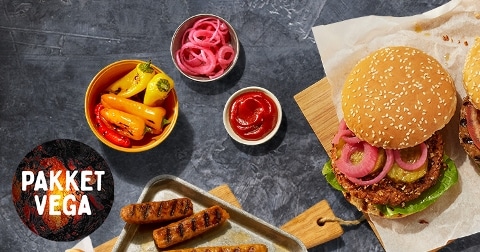 Vegan pakket met gegrilde groenten, gekleurde paprika’s, rode ui, ketchup en een vegetarische burger in een sesambroodje.