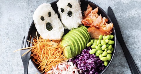 Sushibowl met rijst gevormd als spookjes, avocado, zalm, edamame, wortel, rode kool en surimi