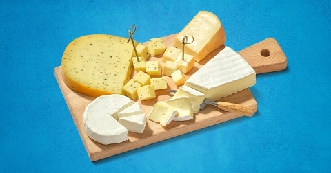 Een assortiment van verschillende kazen op een houten snijplank.