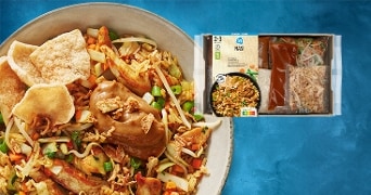 Maaltijdpakket AH nasi met afbeelding van de bereide nasi met groenten, kroepoek en satésaus op een bord