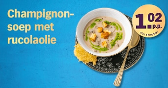 Kom champignonsoep met rucolaolie, croutons en een kaaskoekje op bord, dit gerecht kost 1 euro en 2 cent per persoon op basis van 4 personen