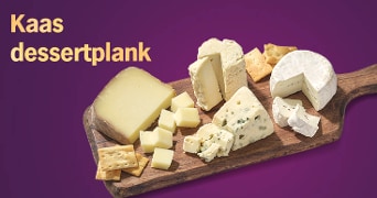 Kaas dessertplank met verschillende soorten kaas en crackers op een houten plank tegen een paarse achtergrond