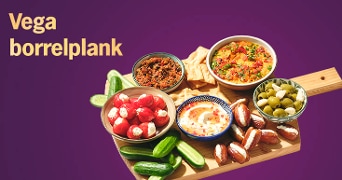 Vegetarische borrelplank met verschillende dips, gevulde pepers, olijven, komkommers, dadels en toastjes op een houten plank, met de tekst 'Vega borrelplank' op een paarse achtergrond