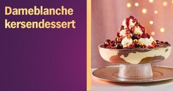 Dame blanche kersendessert in een glazen coupe, geserveerd met kersen, chocoladesaus en bolletjes vanille-ijs