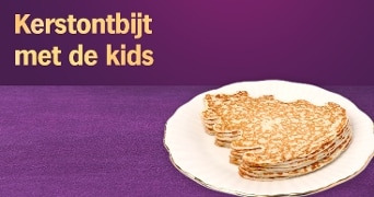 Kerstontbijt met stapel pannenkoeken op wit bord tegen paarse achtergrond