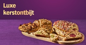 Luxe kerstontbijt met verschillende feestelijke broden en gebak op een houten plank