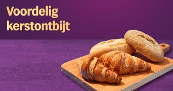 Verschillende broodjes en croissant op een houten plank met de tekst 'Voordelig kerstontbijt' op een paarse achtergrond