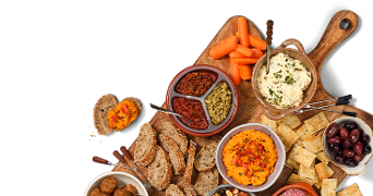 Borrelplank met verschillende soorten brood, smeersels, hummus, wortels, olijven, dip en crackers
